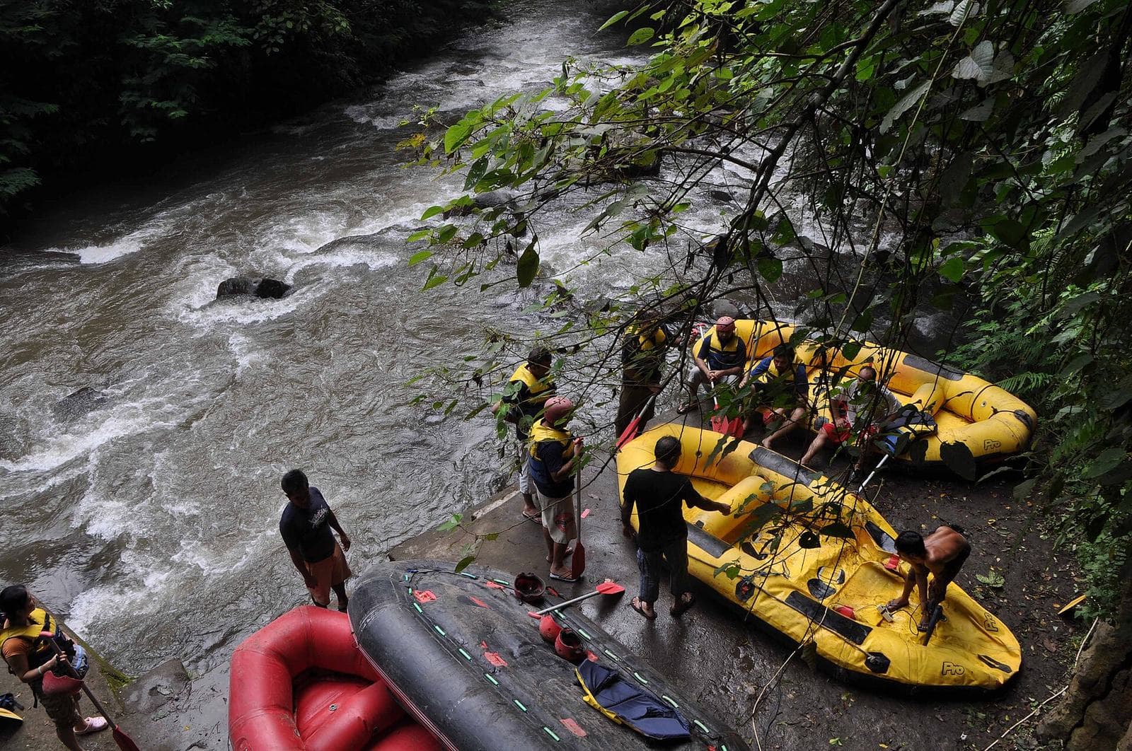 Rafters in a blue raft paddling whitewater on the Ayung River in Bali