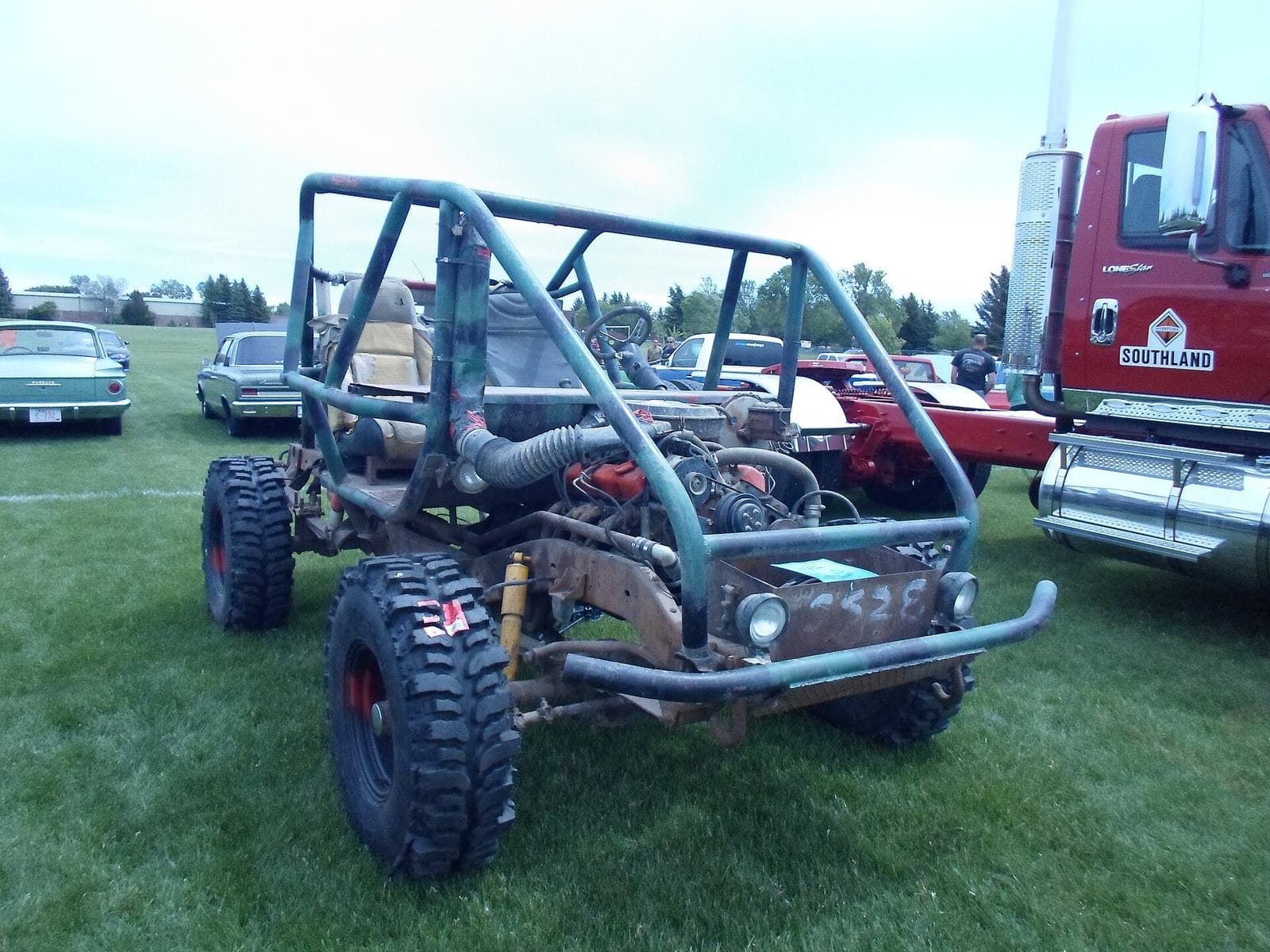 An open off-road buggy driving on a dirt track